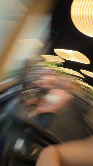 A woman takes a selfie video with a man and others on treadmills in a gym.