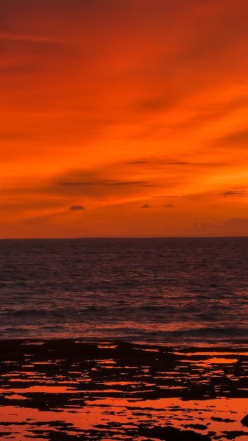 A beautiful fiery orange and red sunset over the ocean.
